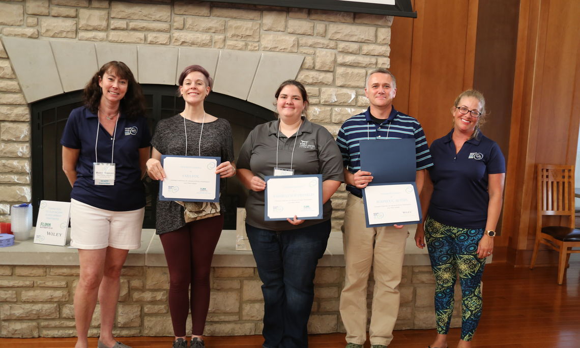 Marcy Dubroff (left) of The POGIL Project, poses with this year's scholarship winners (Sara Fox, Kassie Lynch, Rodney Austin) and presenter Ashley Hill (right).